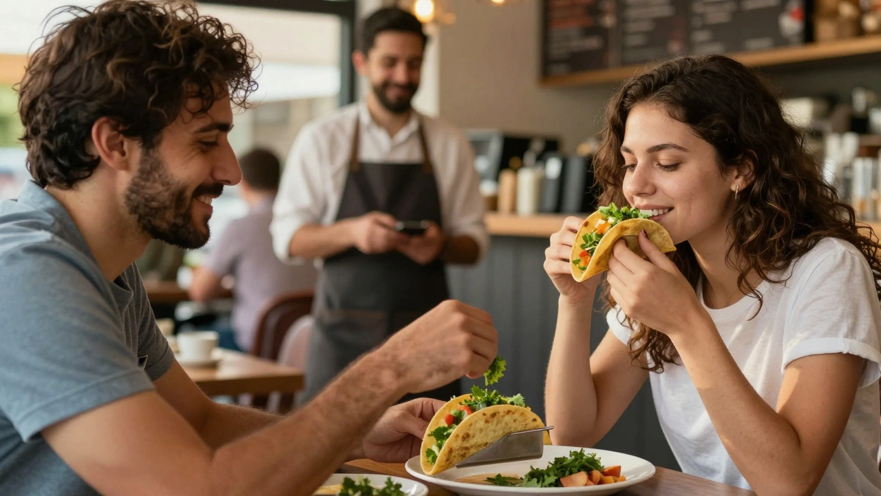 A man carefully removes cilantro from a taco before giving it to his partner in a café.